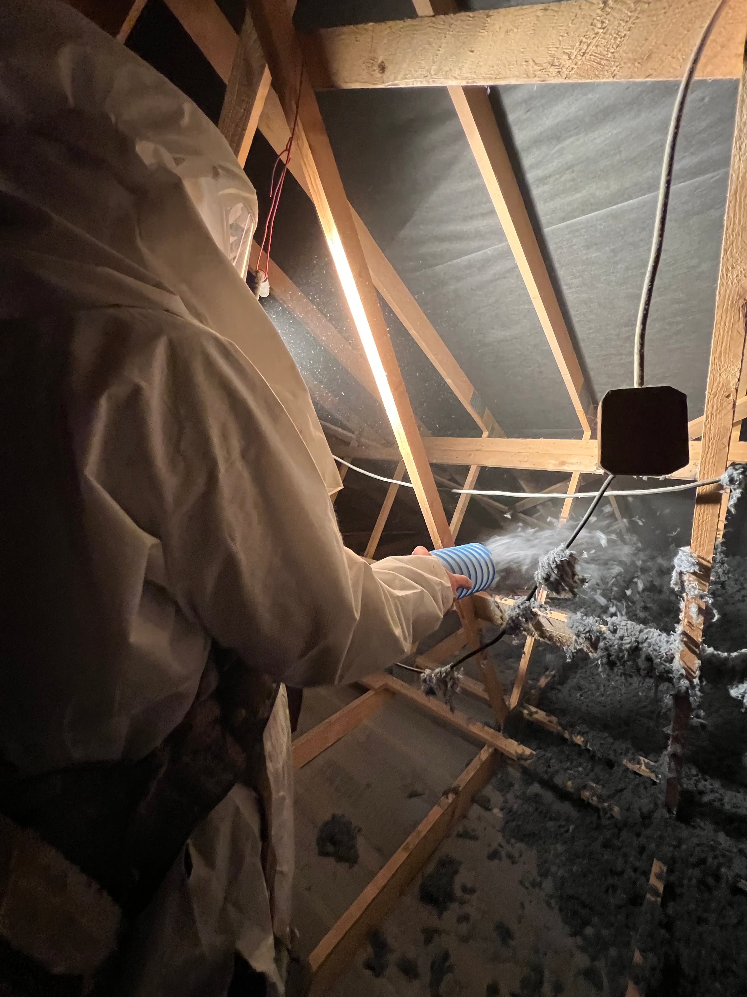 Applicateur Isolatech en plein soufflage de laine de coton dans des combles · isolation thermique sous charpente bois · Saint-Barthélemy (Haute-Saône) · Isolatech