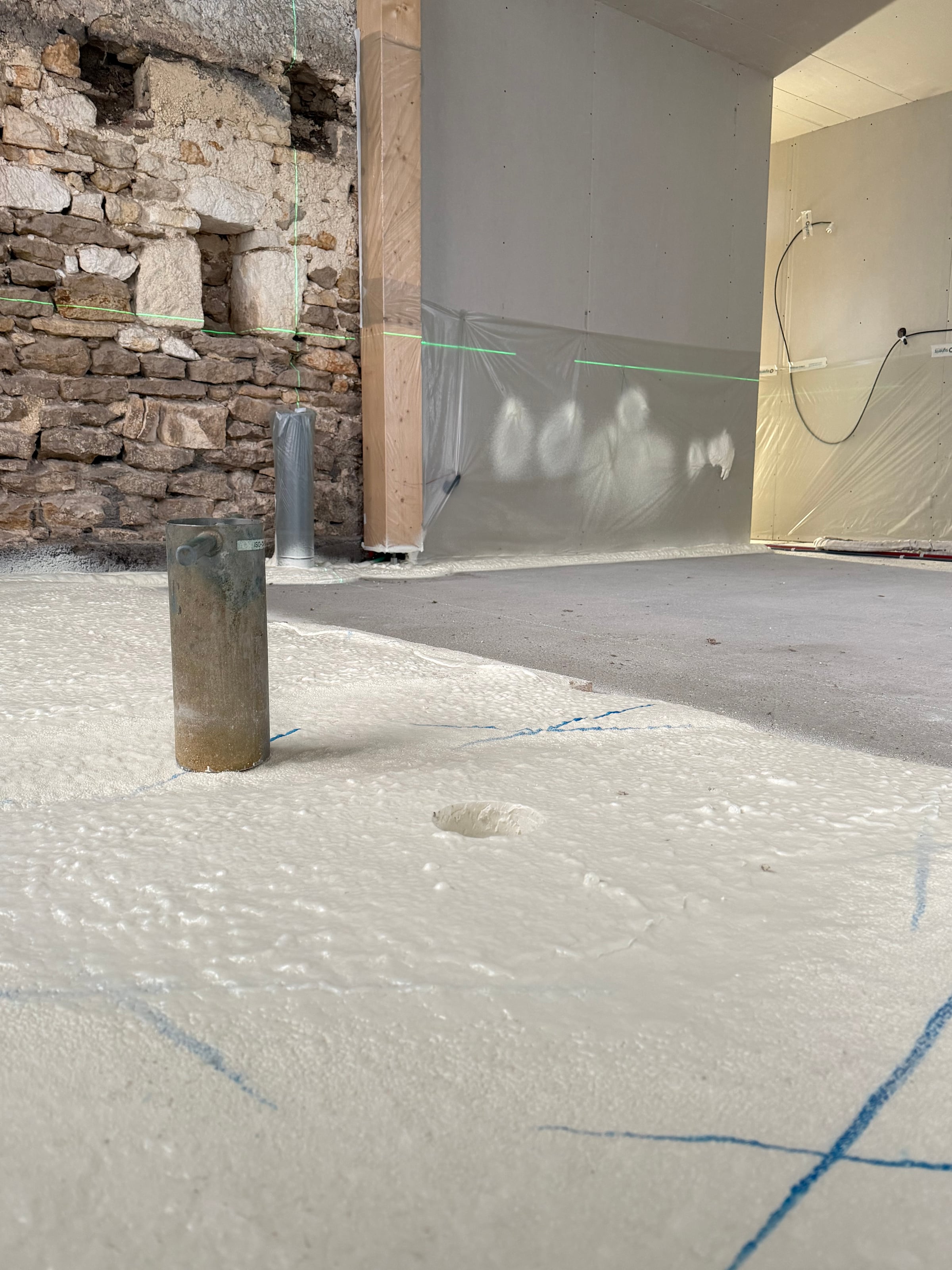 Détail de la projection polyuréthane sur mur en pierre apparente — buse de projection en gros plan · Isolatech